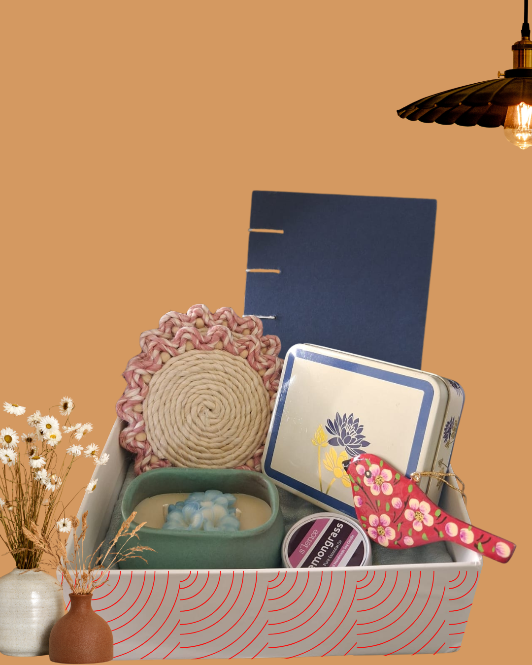 Luxury handcrafted artisanal hamper by The 369 Gift Company featuring woven jute floral coasters, blue hardcover handmade journal, handpainted storage jar, lemongrass handmade candle, paper mache handpainted bird décor, and luxe blue square ceramic jar flower candle by Maison Fourteen Thirty. Perfect for weddings, events, and luxury gifting.