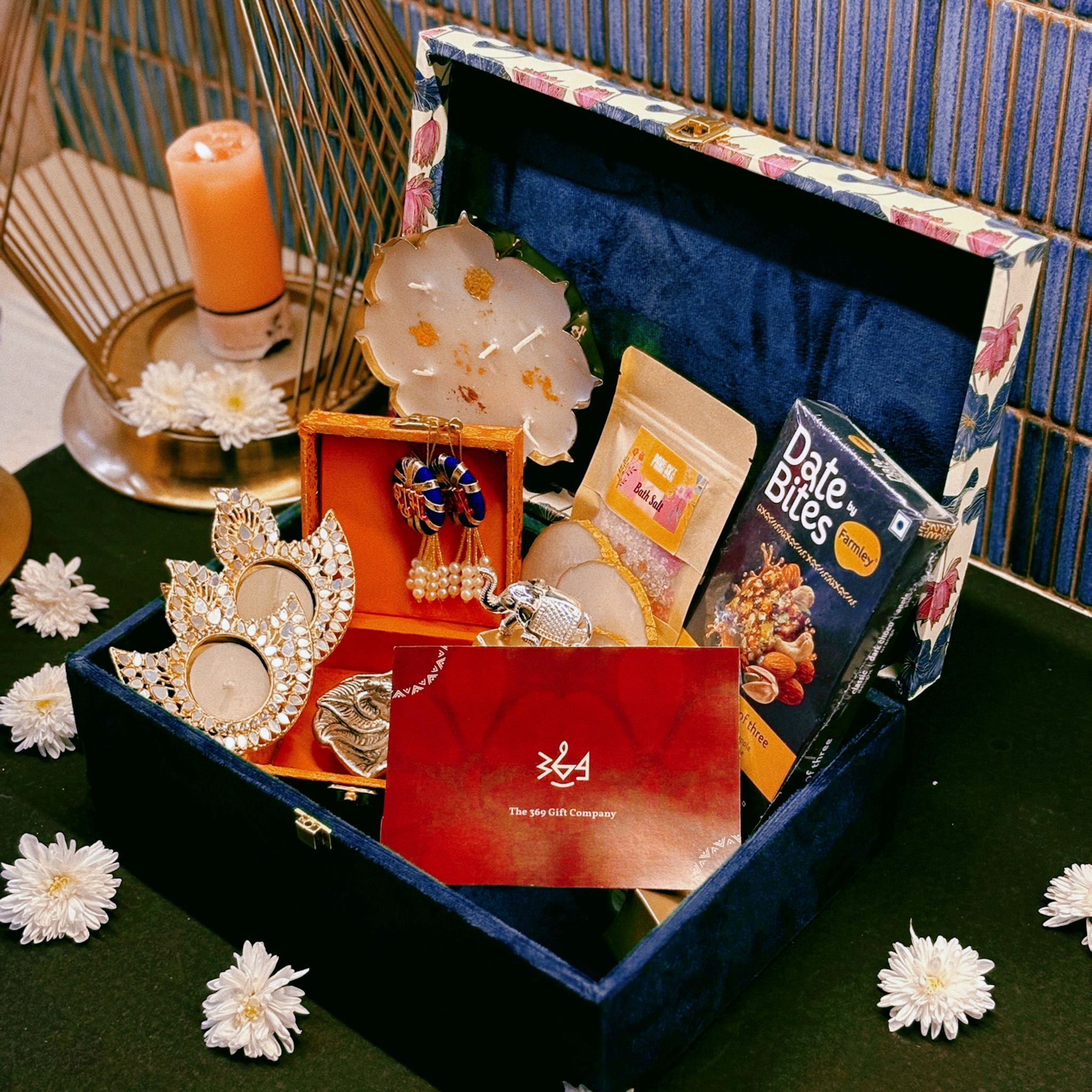 Luxury handcrafted wedding gift hamper by The 369 Gift Company, featuring an Urli Oudh candle, tealight holders, resin coasters, bath salts, chocolates, and decor accents in a lotus trunk box — perfect for weddings, events, and festive gifting.