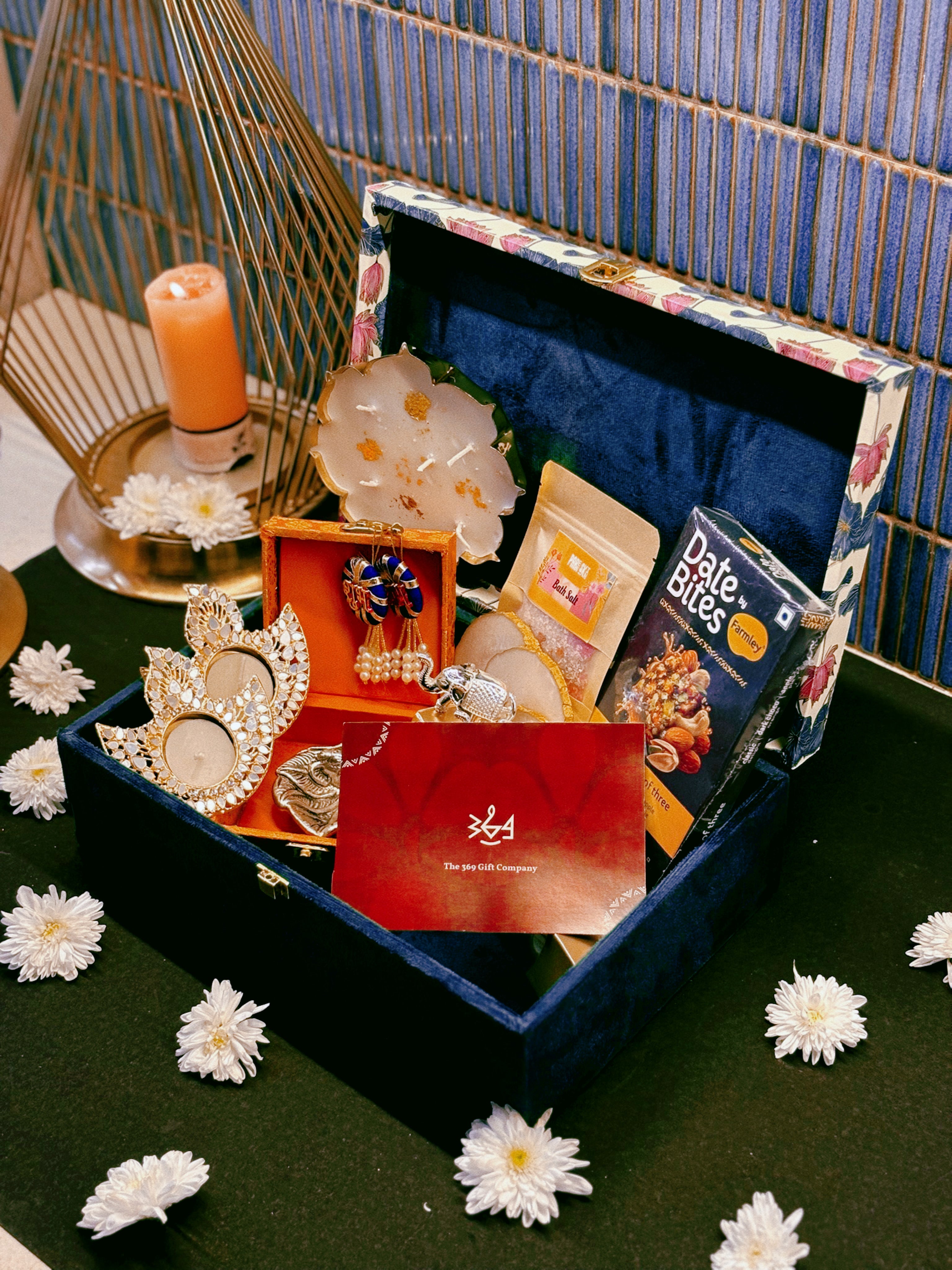 Luxury handcrafted wedding gift hamper by The 369 Gift Company, featuring an Urli Oudh candle, tealight holders, resin coasters, bath salts, chocolates, and decor accents in a lotus trunk box — perfect for weddings, events, and festive gifting.