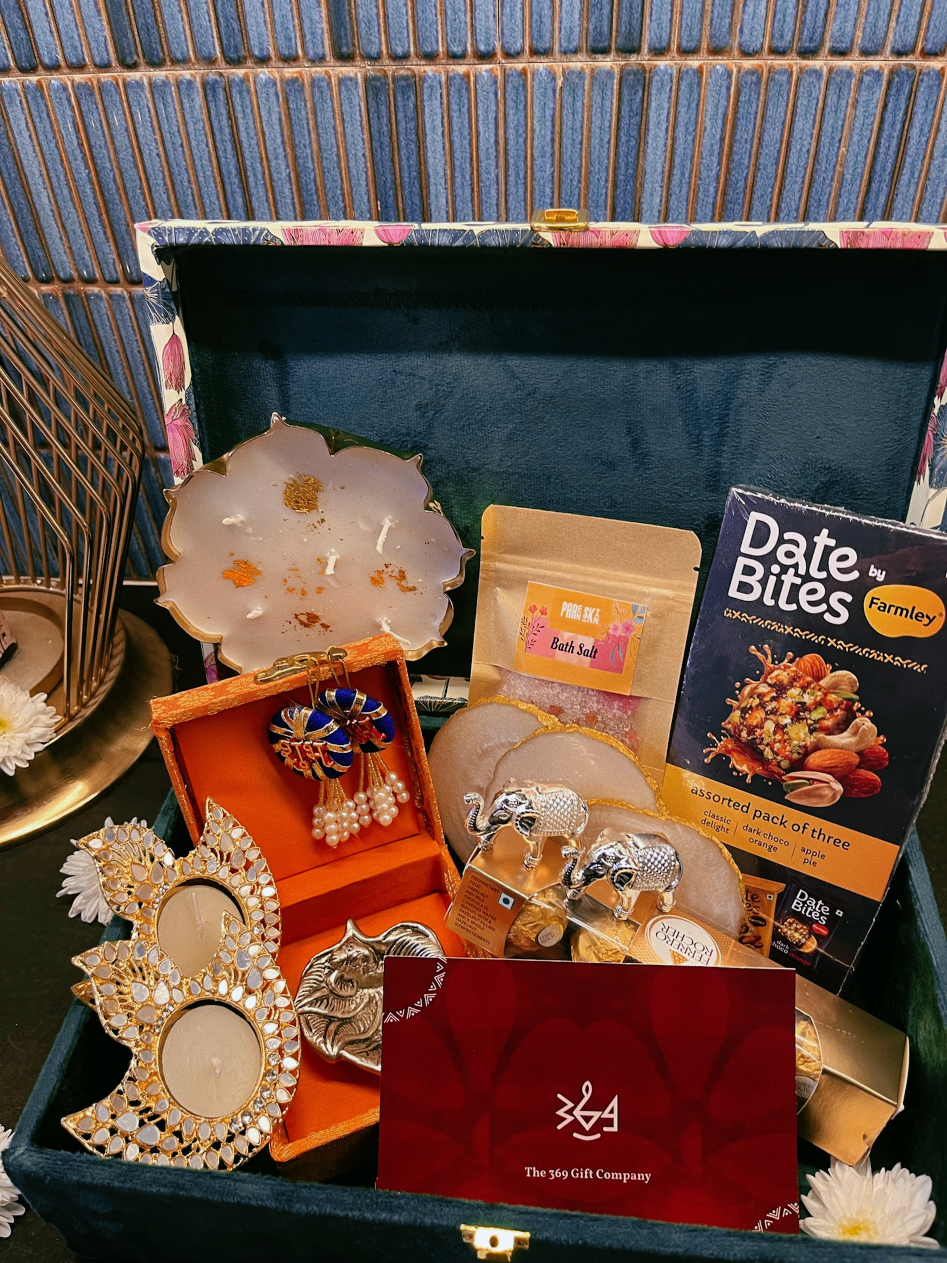 Luxury handcrafted wedding gift hamper by The 369 Gift Company, featuring an Urli Oudh candle, tealight holders, resin coasters, bath salts, chocolates, and decor accents in a lotus trunk box — perfect for weddings, events, and festive gifting.