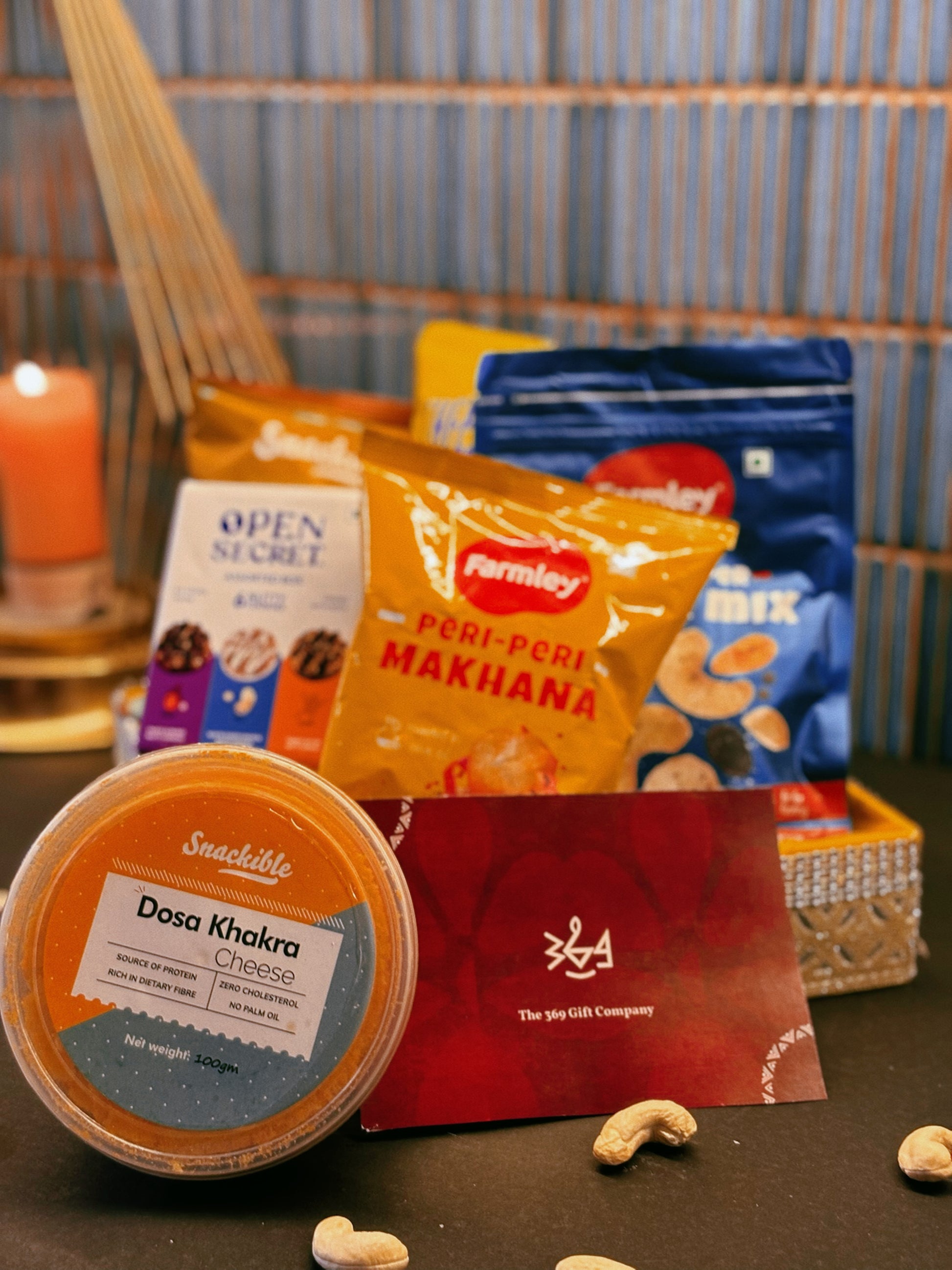 Gourmet artisanal wedding & event snack hamper by The 369 Gift Company featuring Open Secret treats, 4700 BC caramel popcorn, Snackible dosa khakra, cheese & peri peri popcorn, Farmly roasted peri peri makhana, Snackible ragi chips, and Farmly salt & pepper nut mix. Perfect for gifting and celebrations.