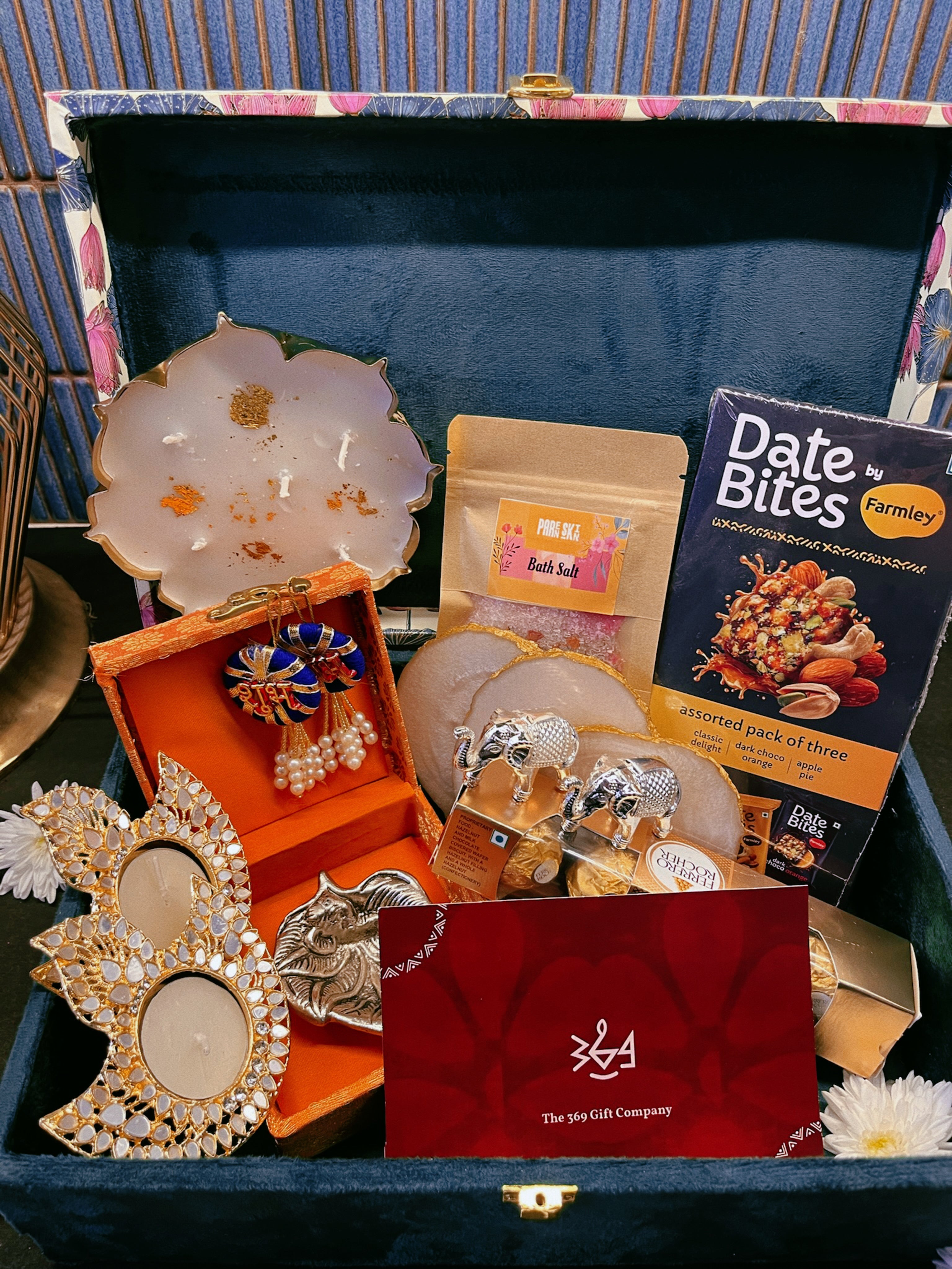 Luxury handcrafted wedding gift hamper by The 369 Gift Company, featuring an Urli Oudh candle, tealight holders, resin coasters, bath salts, chocolates, and decor accents in a lotus trunk box — perfect for weddings, events, and festive gifting.